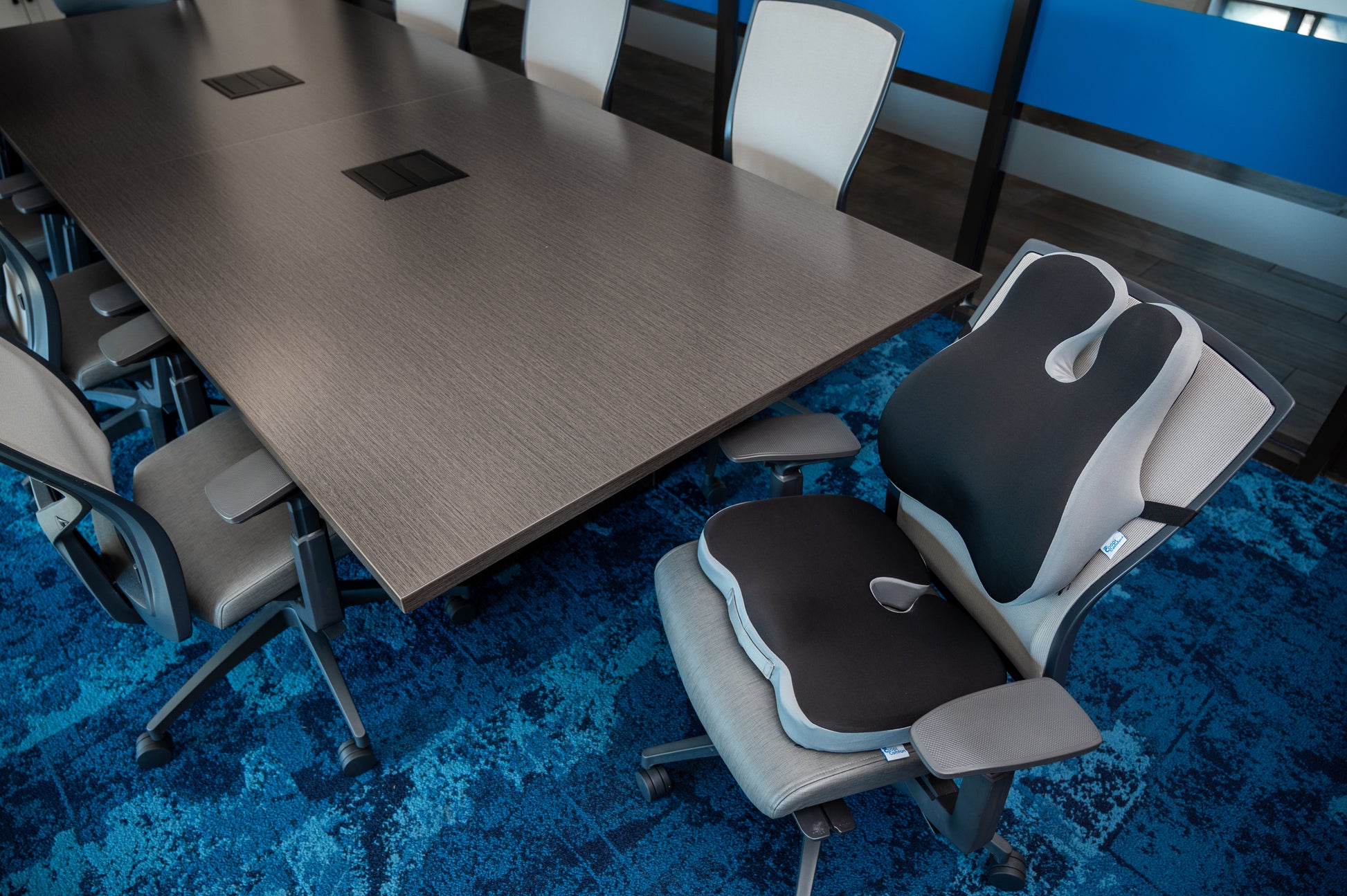 Coopi Comfort back and seat support cushion shown in a professional office environment.