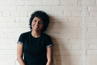 Smiling young woman with curly hair, looking happy and confident.